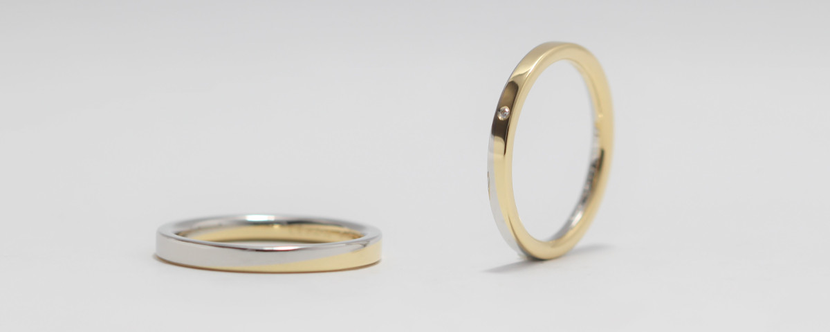 プラチナとゴールドを斜めに貼りあわせた平打ちベースの結婚指輪